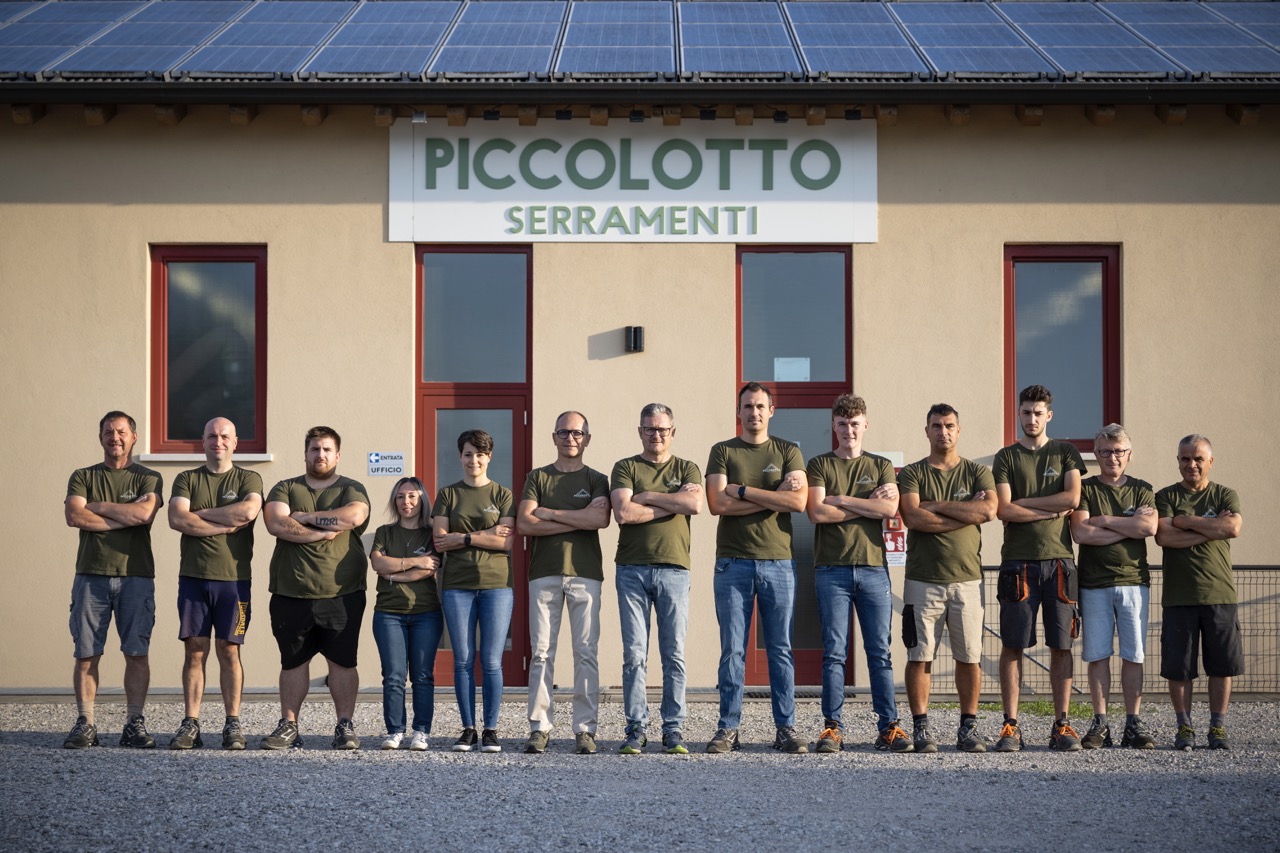 Chi siamo, foto con tutto lo staff di Piccolotto Serramenti di fronte alla produzione di serramenti su misura